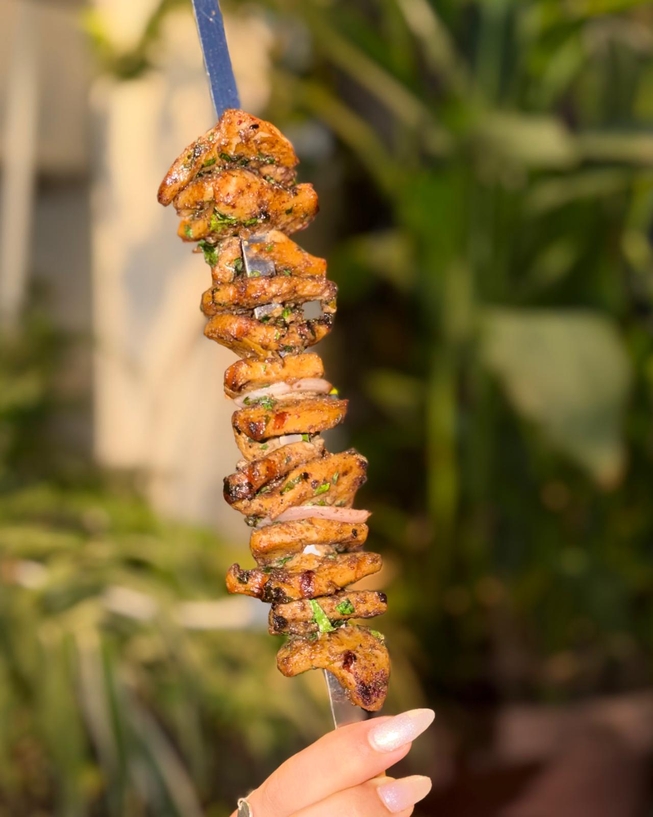 Skewer of seasoned plant-based protein chunks with fresh herbs